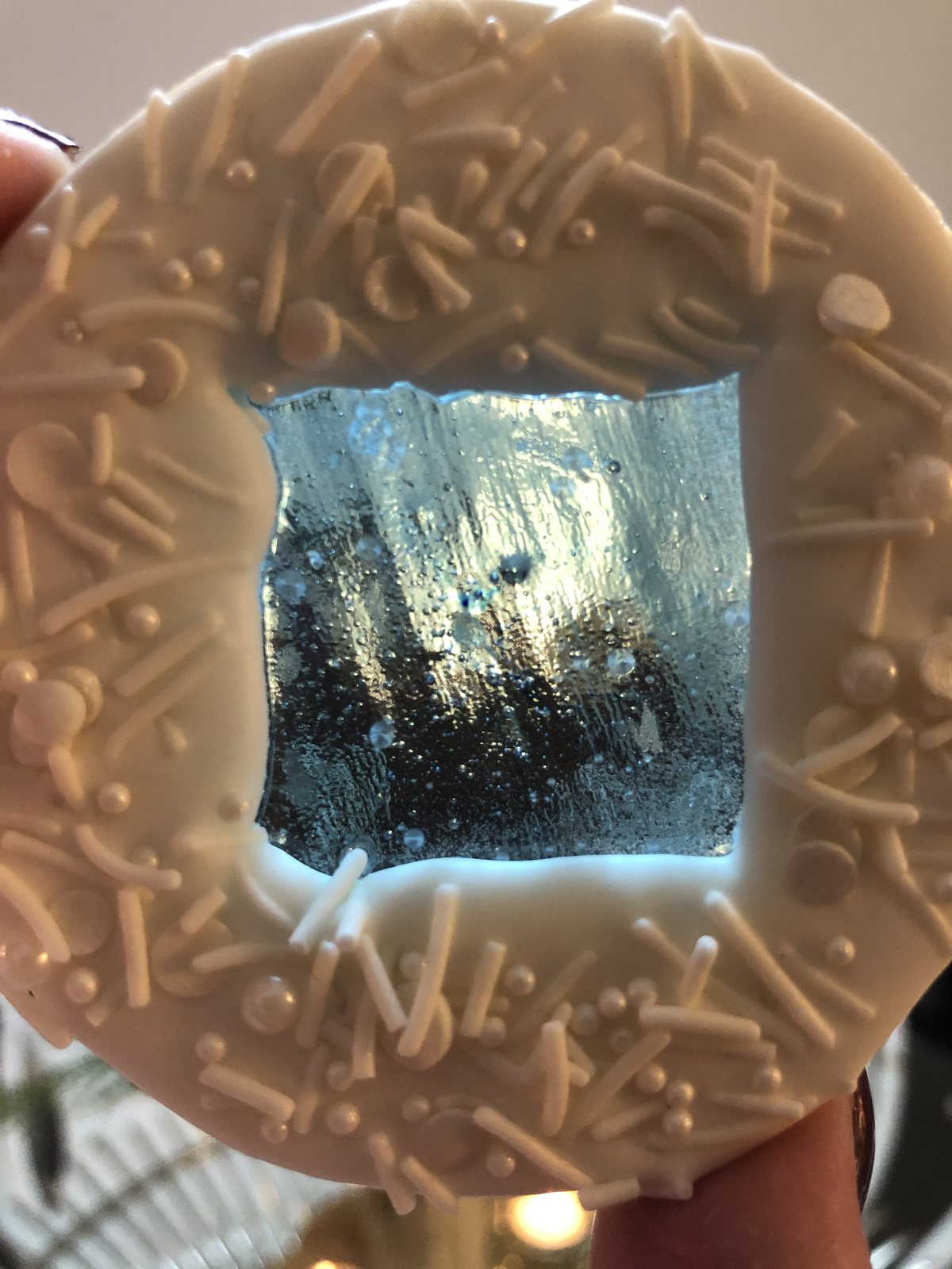 A stained glass cookie: royal-icing border around a tinted melted-sugar window
